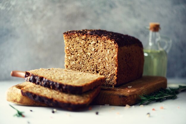 Mani di donna affettare pane appena sostenuto. pagnotta di pane marrone fatto a mano, concetto di panetteria, cibo fatto in casa, alimentazione sana. copia spazio