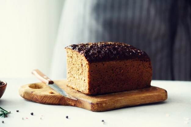 Mani di donna affettare pane appena sostenuto.