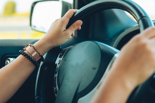 Woman hands on steering wheel close up