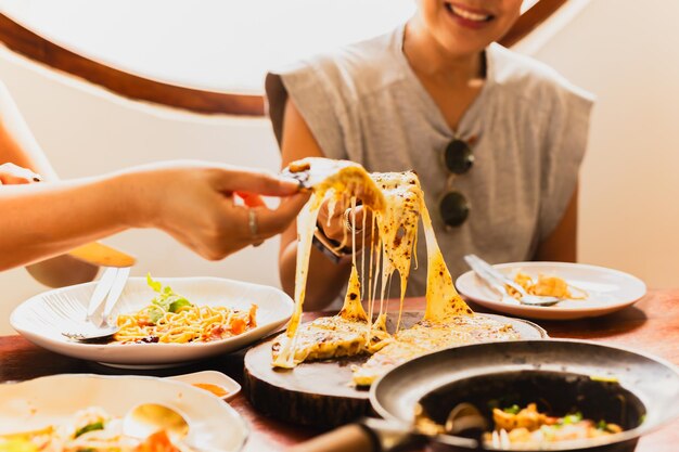 Woman hands taking slices of pizza with friends