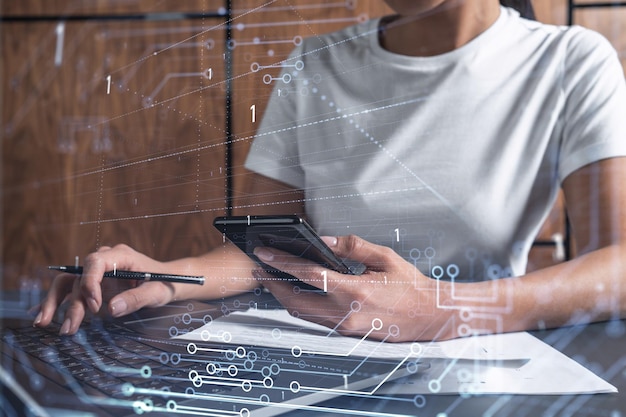 Woman hands typing the keyboard to create innovative software to change the world and provide a completely new service Close up shot Hologram tech graphs Concept of Dev team Casual wear