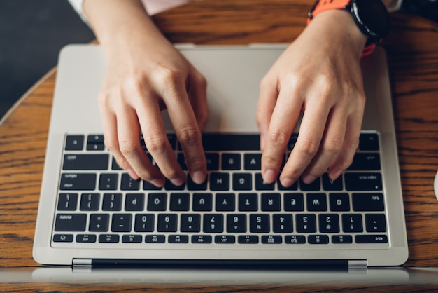 Foto mani della donna che scrivono sul computer portatile