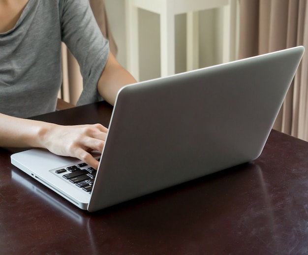 Woman hands using a laptop at home in day time 