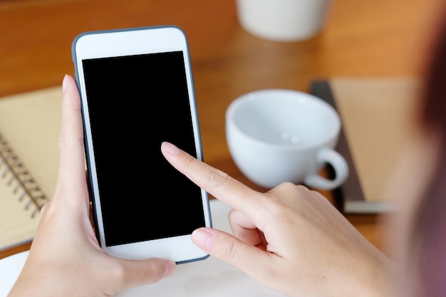 Woman hands using smart phone with blank screen background for mock up