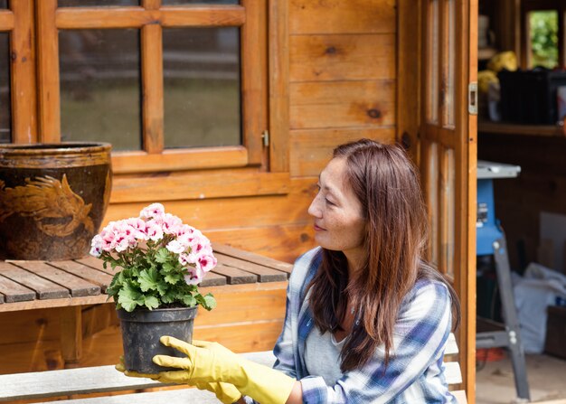 写真 花を保持し、植える黄色の手袋を着用して女性の手