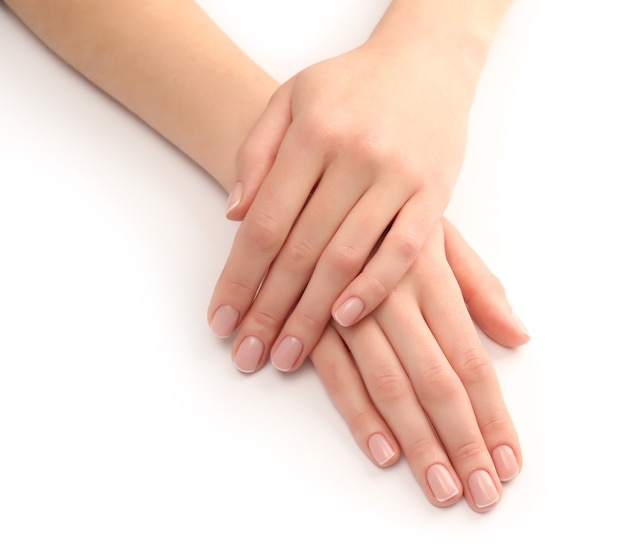 Mani della donna con bella manicure su bianco