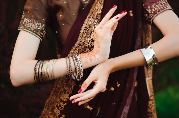 Woman Hands with black mehndi tattoo. Hands of Indian bride woman with black henna tattoos. Fashion.