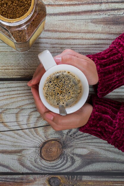 コーヒー カップを持つ女性の手