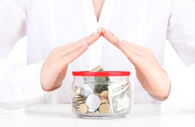 Woman hands with money in glass jar close up