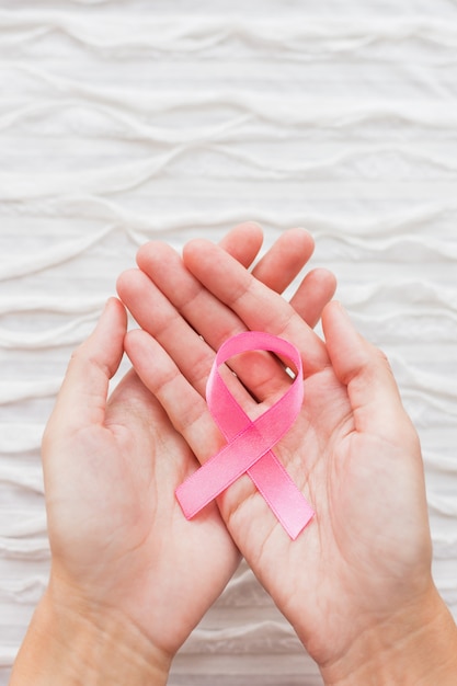 Woman hands with pink ribbon 