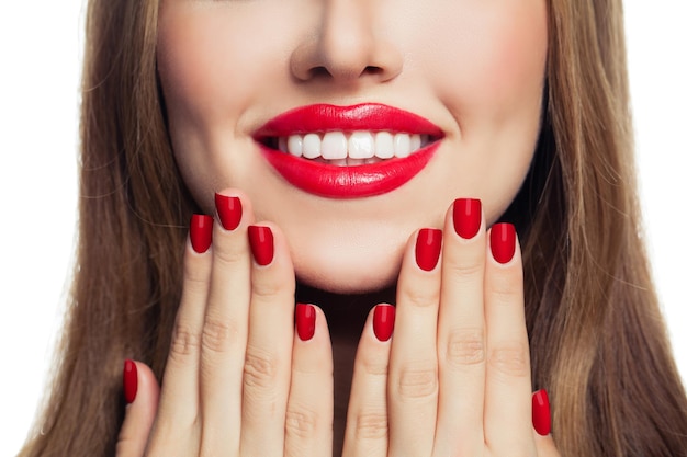 Woman hands with red manicured nails and red lips makeup