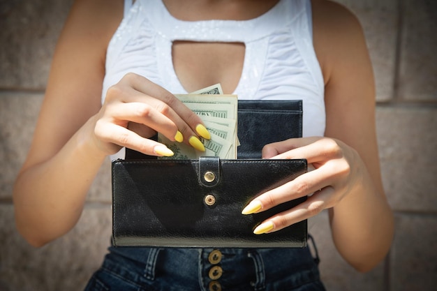 Mani di donna con portafoglio e denaro