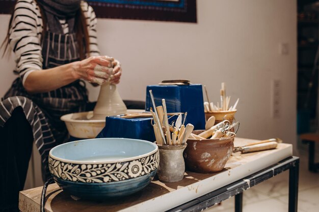 Woman hands working on pottery wheel and making a pot