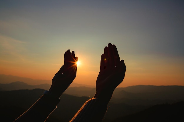 Le mani della donna adorano il tramonto