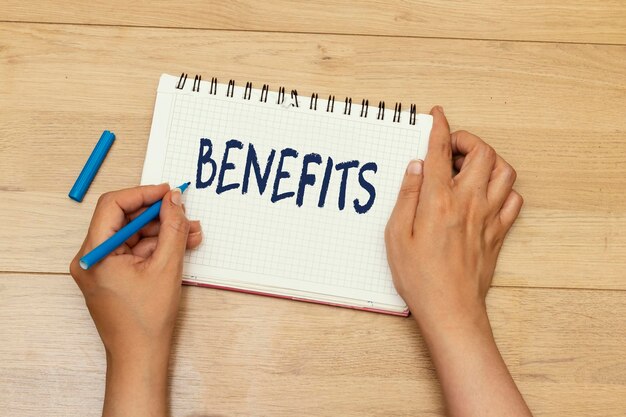 woman hands writing benefits concept on notebook