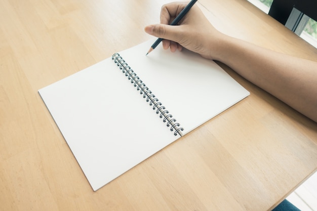 Woman hands writing on book in office