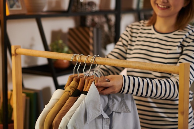 Woman Hanging Clothes on Rail