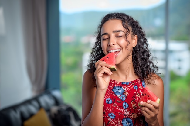 Donna che mangia felicemente anguria fresca rossa