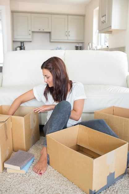 Woman happily unpacking moving boxes