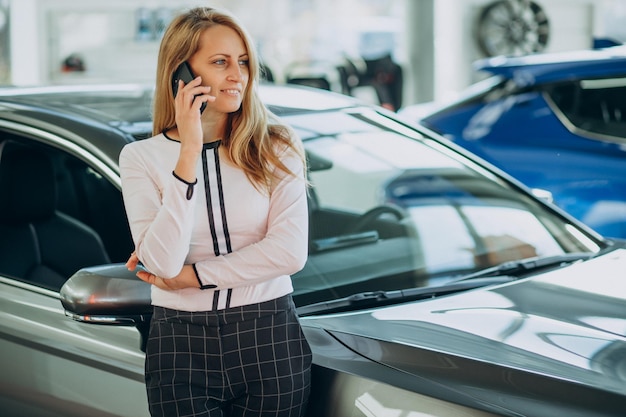 幸せな女性はちょうど彼女の新しい車を買った