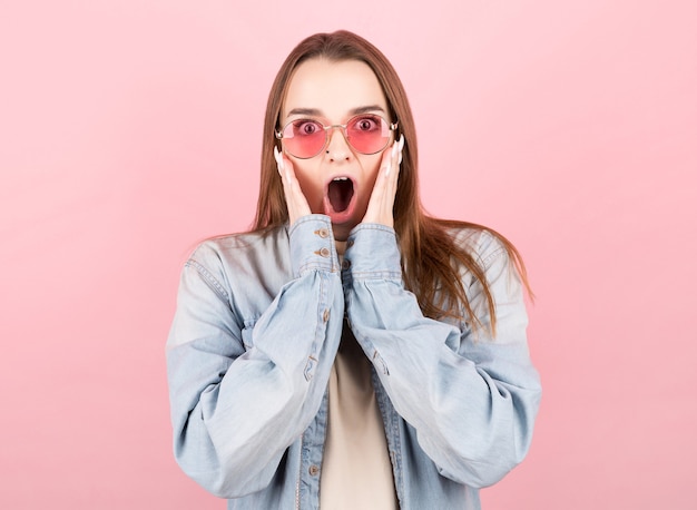 Woman happy and surprised shouts holds cheeks by hand