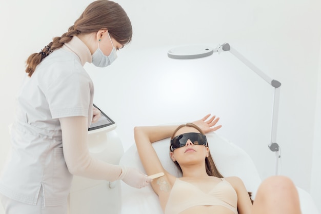 La donna ha una procedura di epilazione laser e cosmetologia