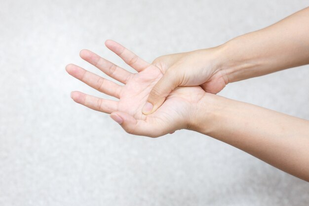 A woman has pains in the hands. The hand hurts a woman on white background.