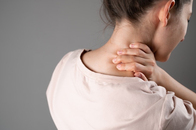 A woman has a sore neck after a hard day at work