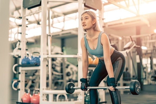 Photo woman has workout in gym with sports equipment sporty female exercise with weight training in the gym