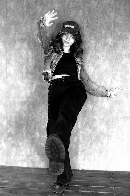 Photo a woman in a hat is standing in front of a wall with a drink in her hand