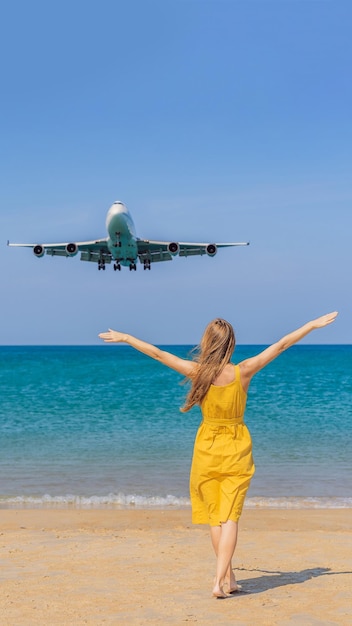여자는 비행기 개념 텍스트 공간을 여행하는 착륙 비행기를 보면서 해변에서 즐거운 시간을 보낸다