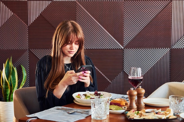 Женщина ужинает в роскошном помещении нового современного роскошного ресторана