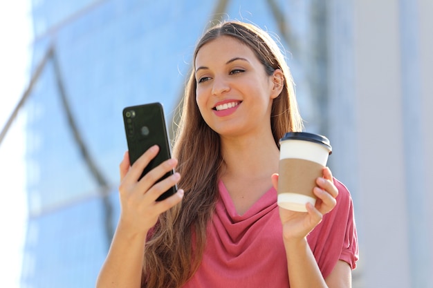 woman have video call with smartphone while holding cup of coffee