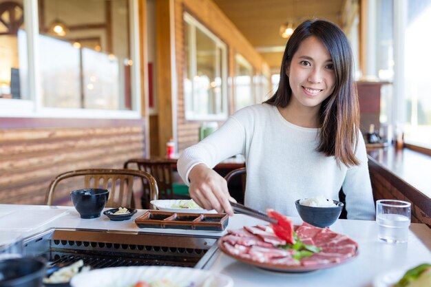 日本食レストランで焼肉を食べる女性