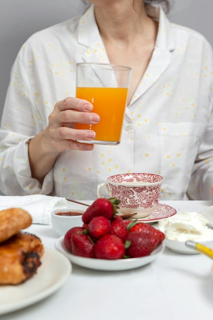 パジャマで朝食を持っている女性