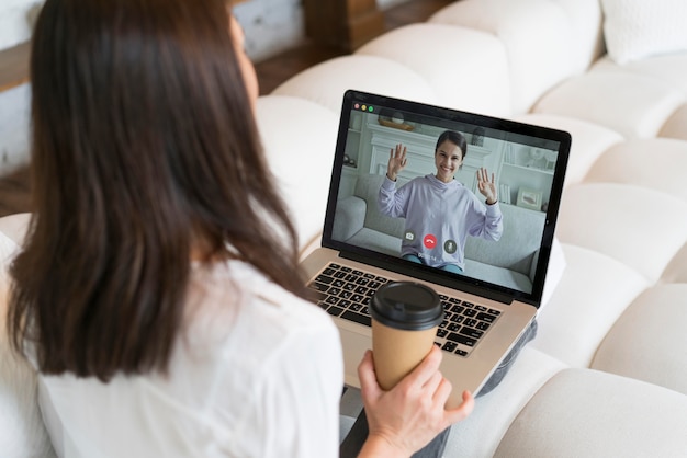 Donna che ha una riunione di lavoro online sul suo laptop