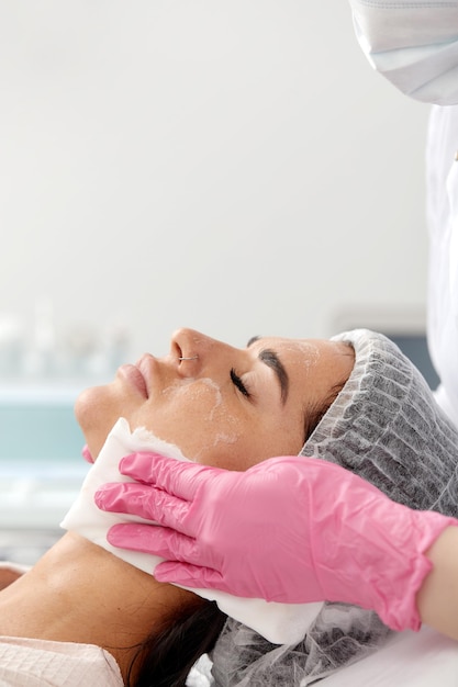 Woman having cleaning facial treatment in spa