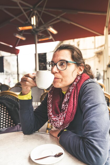 Foto donna che beve caffè in un caffè