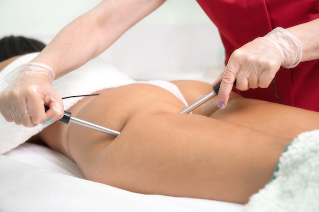 Woman having cosmetic galvanic beauty treatment in spa therapist applying low frequency current