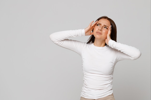 Woman having ear ache/pain, touching her painful head