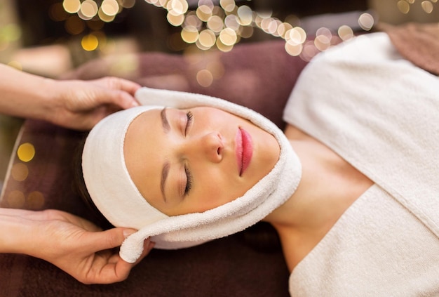 Photo woman having face massage with towel at spa
