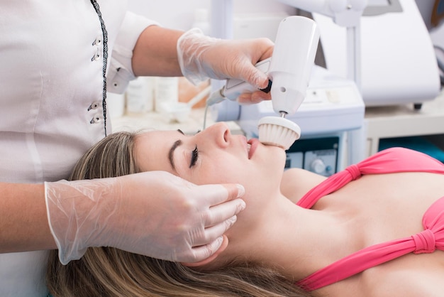 Woman having a facial massage and peeling in beauty salon