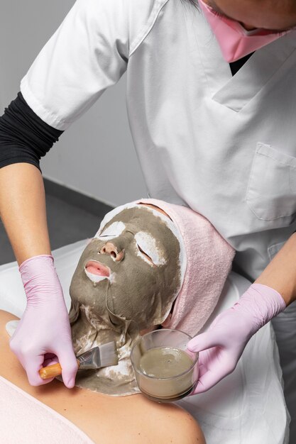 Photo woman having a facial treatment at the beauty salon