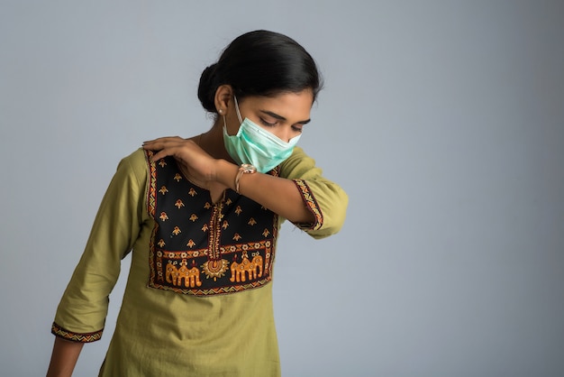 Woman having a fever wearing a medical mask feeling sick and ill.