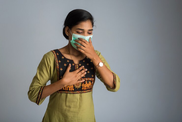 फोटो woman having a fever wearing a medical mask feeling sick and ill.