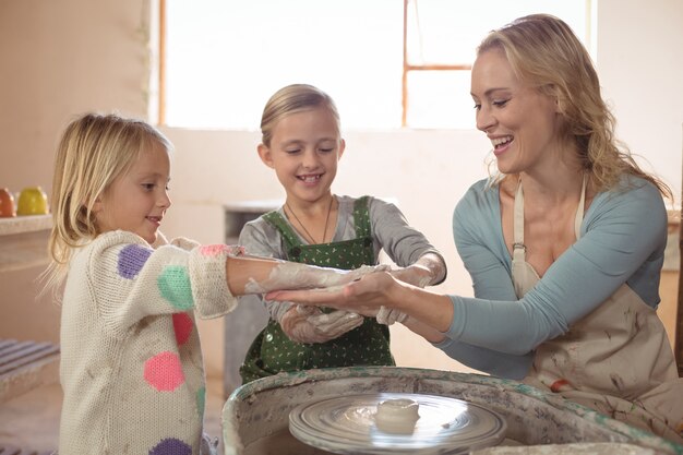 Donna che si diverte con le ragazze mentre si fa la ceramica