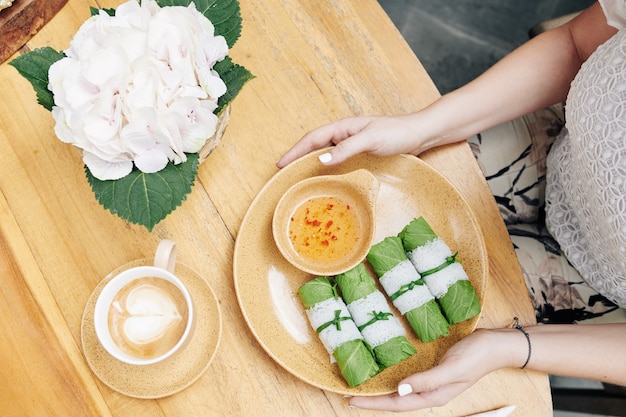 Woman having green spring rolls