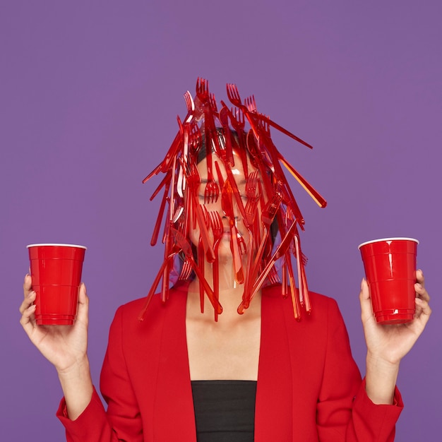 Photo woman having her face covered in plastic while holding plastic cups