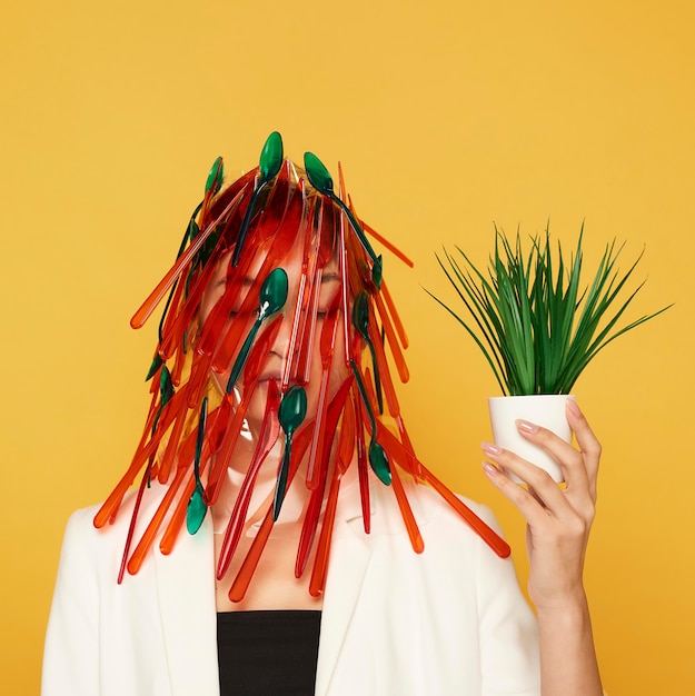 Photo woman having her face covered in red and green spoons and forks