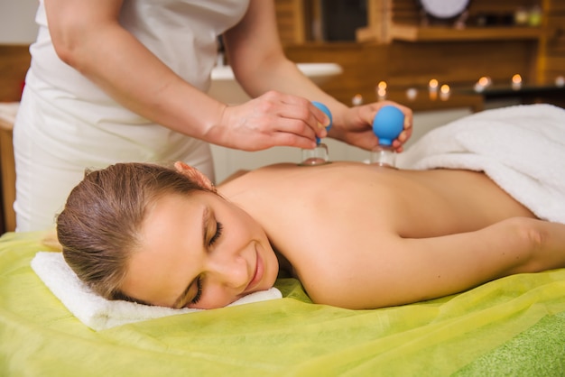 Woman having hot jar vacuum cupping massage in spa center